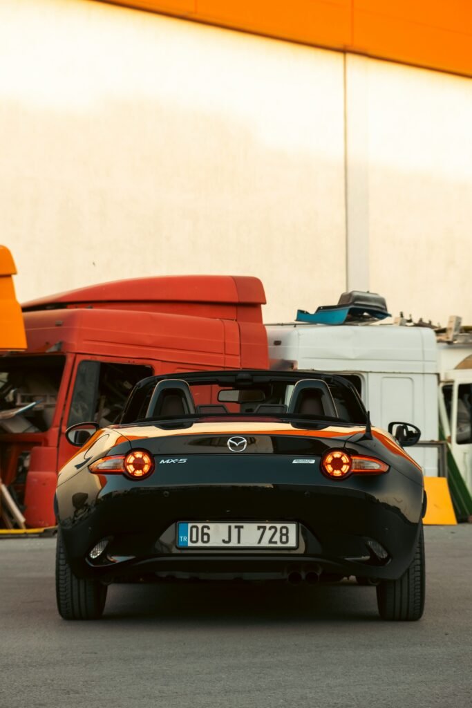 a black car with a red car behind it